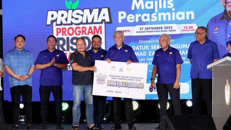 Timbalan Perdana Menteri Datuk Seri Dr Ahmad Zahid Hamidi menyerahkan replika cek Bantuan Musim Tengkujuh Negeri Sabah 2025 kepada wakil RISDA sempena perasmian Karnival RISDA MADANI (KARRISMA) Sabah 2025 di Padang Kota Belud hari ini - fotoBERNAMA