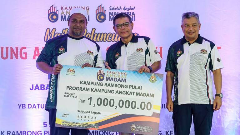Menteri Dalam Negeri Datuk Seri Saifuddin Nasution Ismail menyampaikan sumbangan Kampung Angkat MADANI kepada wakil Kampung Rambong Pulai, Mohd Shukri Shahabudin pada Majlis Peluncuran Kampung Angkat dan Sekolah Angkat MADANI Jabatan Imigresen Malaysia di Sekolah Kebangsaan Rambong Pulai di sini hari ini -fotoBERNAMA