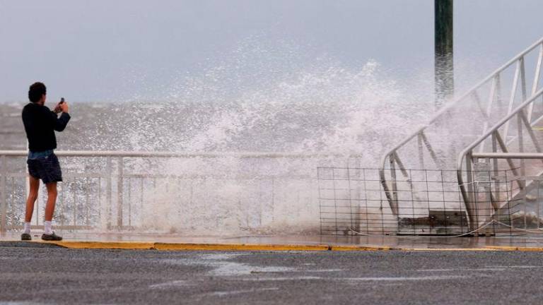 A wave crashes ashore as the region prepares for the possible arrival of Tropical Storm Debby, which is strengthening as it moves through the Gulf of Mexico - AFPpix