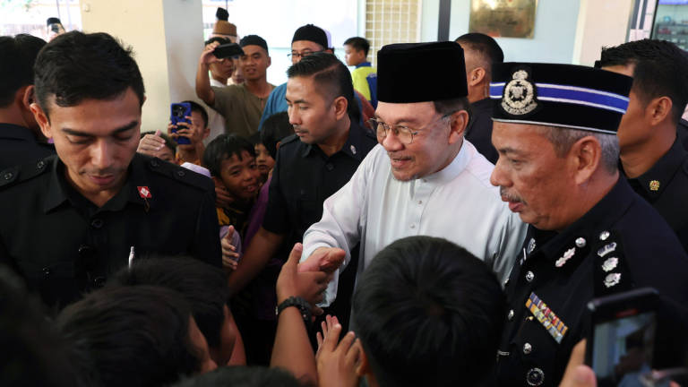 Perdana Menteri Datuk Seri Anwar Ibrahim (tengah) beramah mesra dengan kanak-kanak selepas menunaikan solat Jumaat di Surau Al-istiqlal Presint 14 hari ini. - BERNAMA