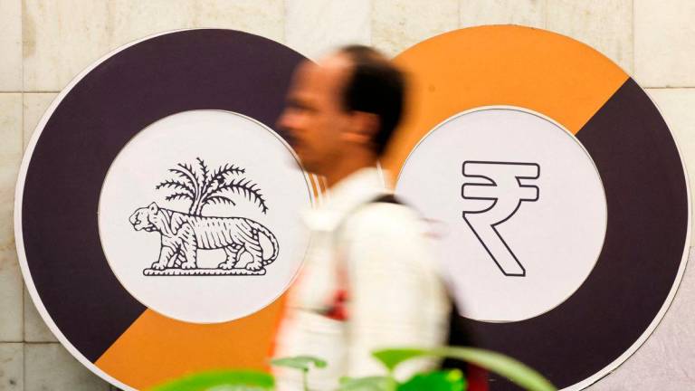 A man walks past a logo of the Reserve Bank of India (RBI) and the Indian Rupee inside the RBI headquarters in Mumbai, India, December 6, 2024. REUTERSpix
