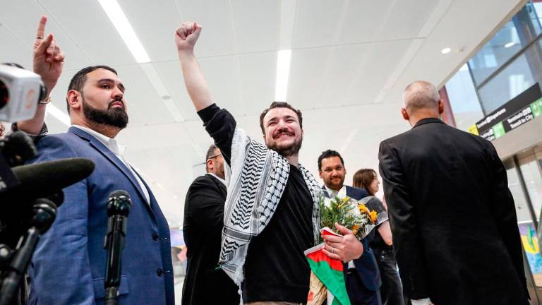 Former Columbia Univrsity student Mahmoud Khalil raises his fist after speaking to the press as he arrives at Newark airport in Newark, New Jersey, on June 21, 2025. - kena betancur / AFP