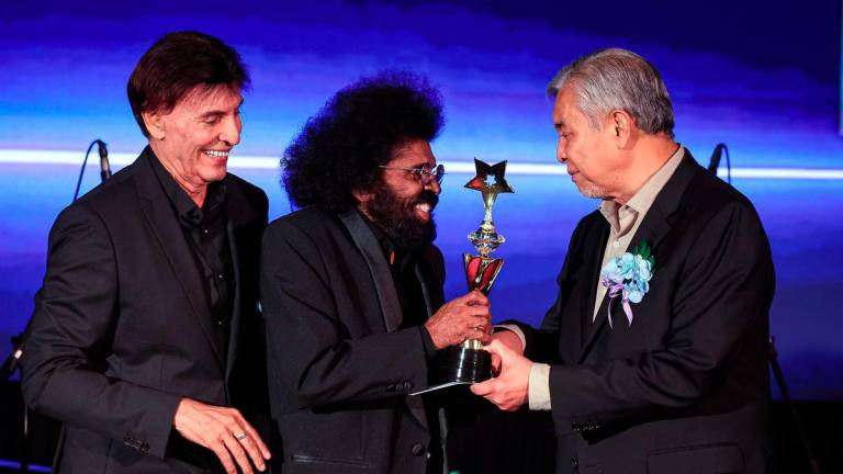 Deputy Prime Minister, Datuk Seri Dr Ahmad Zahid Hamidi, presenting the Singer Icon Award to renowned singer Datuk David Arumugam (second from left) during the *Budi Kasih Malaysia* Concert yesterday. Also present was the Chairman of the National Artistes Welfare Foundation (YKAT), Datuk Irwan Shah Abdullah (left). – BERNAMA