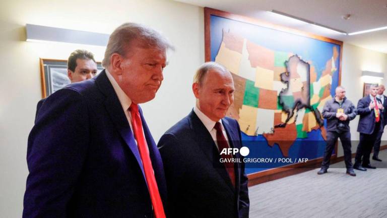 In this pool photograph distributed by the Russian state agency Sputnik, US President Donald Trump (L) and Russian President Vladimir Putin (R) walk to hold a joint press conference following a US-Russia summit on Ukraine at Joint Base Elmendorf-Richardson in Anchorage, Alaska, on August 15, 2025. - POOL via AFP