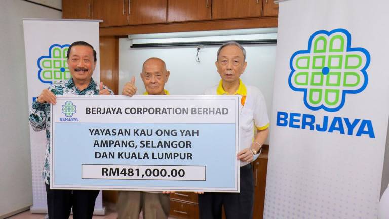 (From left) Tan presenting a mock cheque to foundation president Wong and vice-president Lim Thang Soon. – ADIB RAWI YAHYA/THESUN