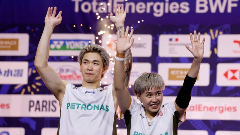 Badminton - BWF World Championships - Adidas Arena, Paris, France - August 31, 2025 Mixed doubles gold medallists Malaysia’s Tang Jie Chen and Ee Wei Toh celebrate on the podium. - REUTERS/Stephanie Lecocq