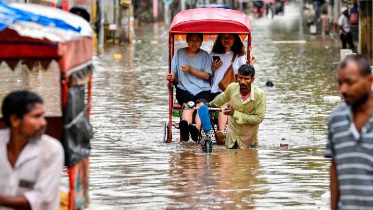 Women commute in cycle rickshaws through a flooded street after heavy rains in Guwahati, in India’s Assam state on May 31, 2025. AFPpix
