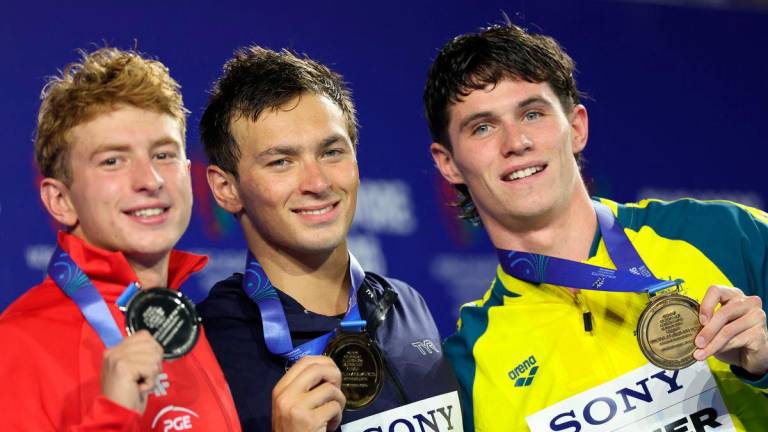 Gold medallist Luca Urlando of the U.S. celebrates on the podium during the medal ceremony with silver medallist Poland’s Krzysztof Chmielewski and bronze medallist Australia’s Harrison Turner - REUTERS