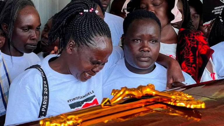 Agnes Cheptegei mourns next to the coffin of her daughter and Olympian Rebecca Cheptegei, who died after her former boyfriend doused her in petrol and set her ablaze, at the Moi Teaching &amp; Referral Hospital (MTRH) funeral home, in Eldoret - REUTERSpix