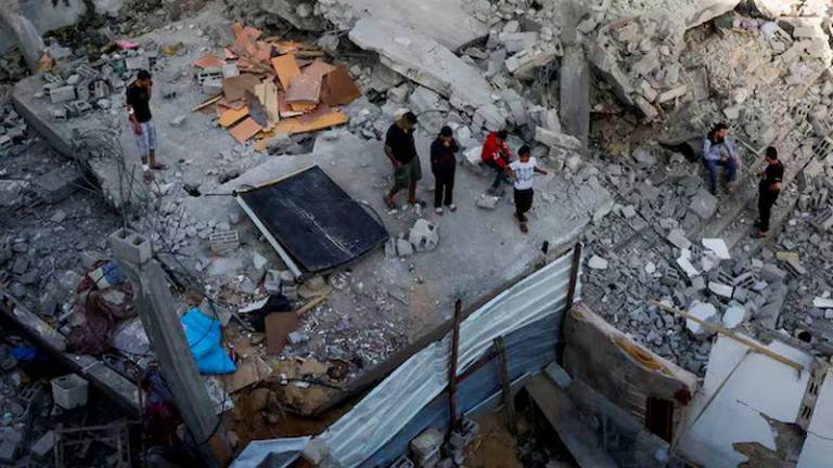 Palestinians inspect the site of an Israeli strike on a house, in Khan Younis in the southern Gaza Strip, May 3, 2025. REUTERS/Hatem Khaled