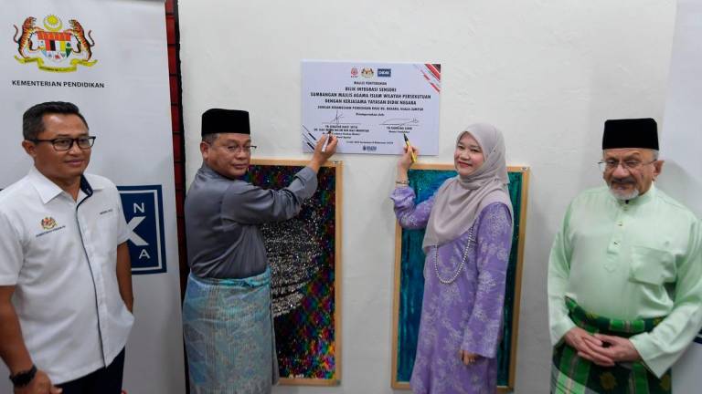Menteri di Jabatan Perdana Menteri (Hal Ehwal Agama) Datuk Dr Mohd Na’im Mokhtar bersama Menteri Pendidikan Fadhlina Sidek menandatangan plak perasmian pada Majlis Pelancaran Program Makanan Tambahan (PMT) Pelajar Menengah dan Bilik Multisensor di Sekolah Kebangsaan Pendidikan Khas Kampung Baharu - BERNAMA
