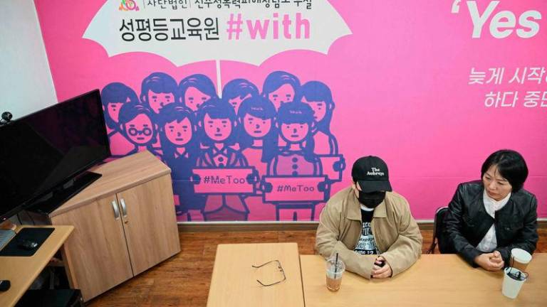 On Ji-goo (L), who wanted to use her pen name and declined to reveal her face for security reasons, and Jung Yun-jung (R), an activist who supported On throughout her trials, attending an interview with AFP at a support centre for victims of sexual violence in Jinju - AFPpix