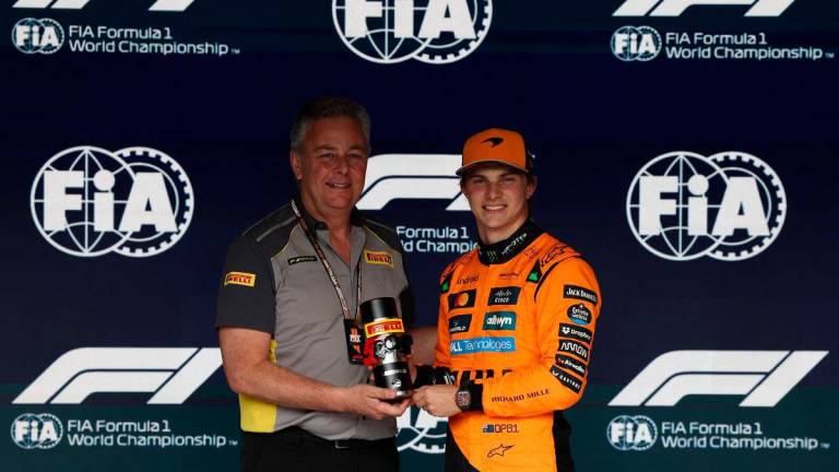 McLaren’s Oscar Piastri poses with a trophy after qualifying in pole position for the sprint race - REUTERS