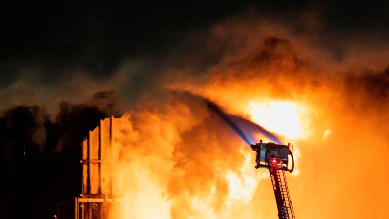 Hoses mounted on the ladder of a firefighting vehicle are used to contain a fire that broke out at the Chevron refinery, in El Segundo, California, U.S., October 2, 2025. REUTERS/Daniel Cole