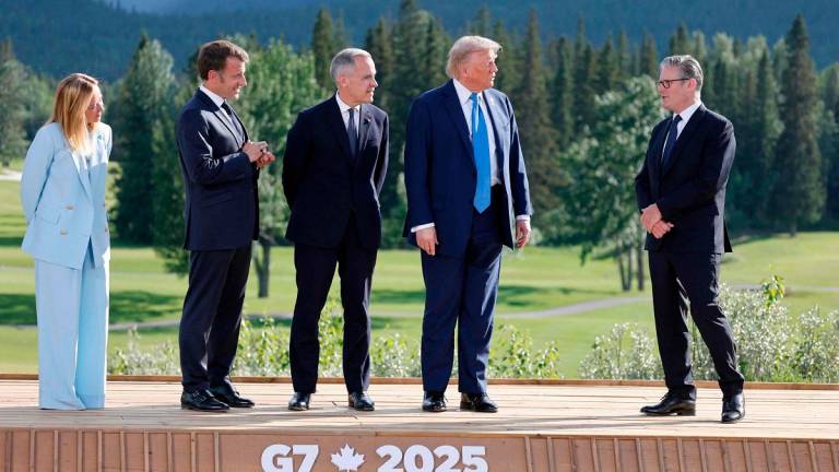 (L-R) Italian Prime Minister Giorgia Meloni, French President Emmanuel Macron, Canadian Prime Minister Mark Carney, US President Donald Trump and British Prime Minister Keir Starmer wait ahead of a family photo during the Group of Seven (G7) Summit at the Kananaskis Country Golf Course in Kananaskis, Alberta, Canada on June 16, 2025. - Ludovic MARIN / POOL / AFP