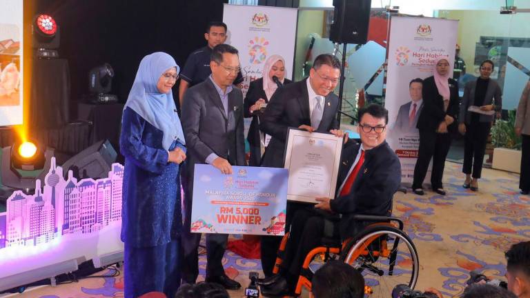 Nga presenting an award at the event, alongside Housing and Local Government Ministry deputy secretary-general (Sustainability and Strategic Planning) Tuan Mohd Hazli Ahmad Adnan and Sepang Municipal Council president Dr Ani Ahmad. – ADIB RAWI YAHYA/THESUN