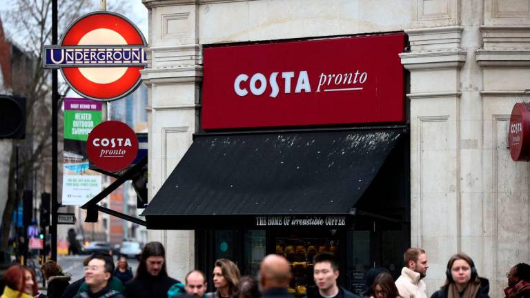 FILE PHOTO: People walk outside a Costa coffee shop in London, Britain, March 4, 2023. REUTERS/Henry Nicholls/File Photo