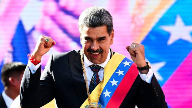 Venezuela's President Nicolas Maduro gestures to supporters after delivering a speech in front of Miraflores presidential palace in Caracas on January 10, 2025. - AFPPIX