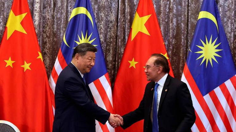 Prime Minister Datuk Seri Anwar Ibrahim (right) shakes hands with Chinese President Xi Jinping - Photo by BERNAMA