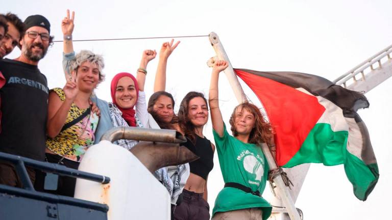 Greta Thunberg and other crew members flash victory signs from their ship, part of the Global Sumud Flotilla aiming to reach Gaza and break Israel’s naval blockade, as they sail off Crete island, Greece, September 25, 2025. REUTERS/Stefanos Rapanis