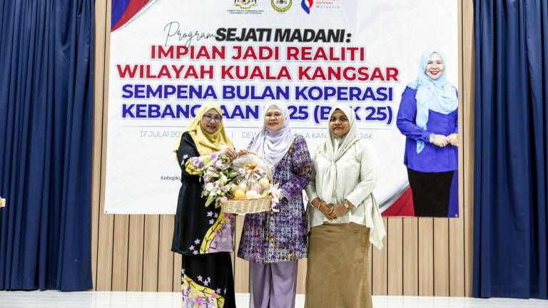 Perak State Executive Councillor for Women’s Development, Family, Social Welfare, Entrepreneur Development and Cooperatives, Datuk Salbiah Mohamed (centre), receives a souvenir from the Director of the Perak branch of the Malaysian Cooperative Commission, Zuhaini Romli (left), at the Sejati Madani Programme: Turning Dreams into Reality for the Kuala Kangsar Region in conjunction with the 2025 National Cooperative Month at the Perak State Department of Irrigation and Drainage Hall today. – BERNAMA
