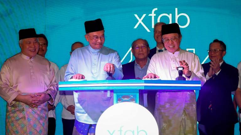 Perdana Menteri Datuk Seri Anwar Ibrahim (dua, kiri) bersama Premier Sarawak Tan Sri Abang Johari Tun Openg (dua, kanan) melakukan gimik perasmian peluasan fasiliti X-FAB Sarawak di sini hari ini. - BERNAMA