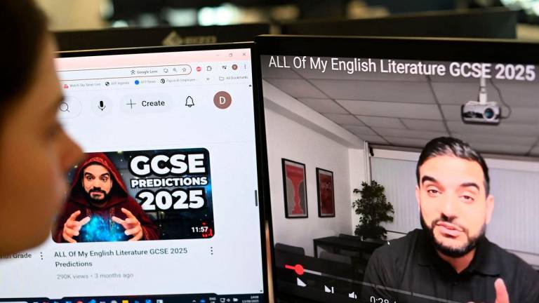 A posed photograph taken as an illustration in London on August 13, 2025 shows a journalist looking at a video by former teacher Waqar Malik on his “Mr Everything English” channel. AFPPix