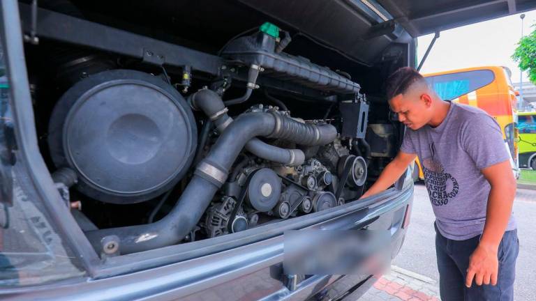 Mara Liner express bus driver Shahrul Azdmin, 36, inspects his vehicle before embarking on a long distance drive. – ADIB RAWI YAHYA/THESUN