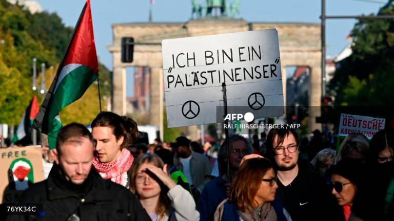 Participants march with a placard reading ‘I am a Palestinian’ during a demonstration under the motto ‘Draw the red line with us: Together for Gaza!’ near the Brandenburg Gate in the center of Berlin on September 27, 2025. (Photo by RALF HIRSCHBERGER / AFP)
