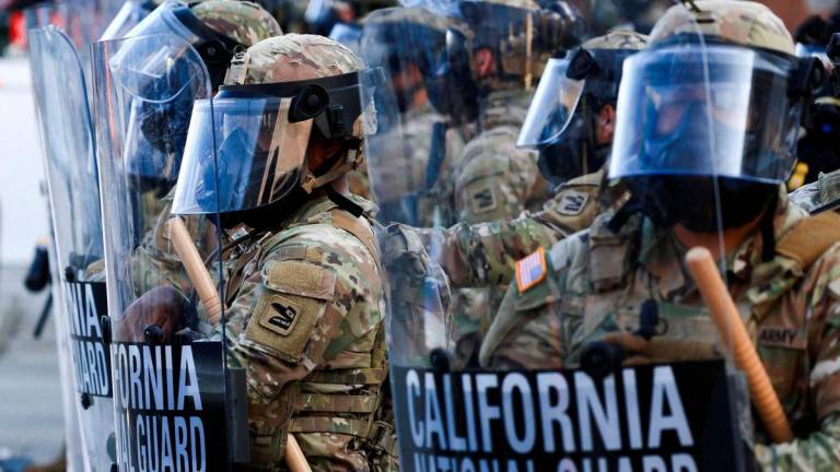 FILE PHOTO: National Guard troops wear gas masks during protests against federal immigration sweeps, in Los Angeles, California, U.S., June 12, 2025. REUTERS/David Swanson/File Photo