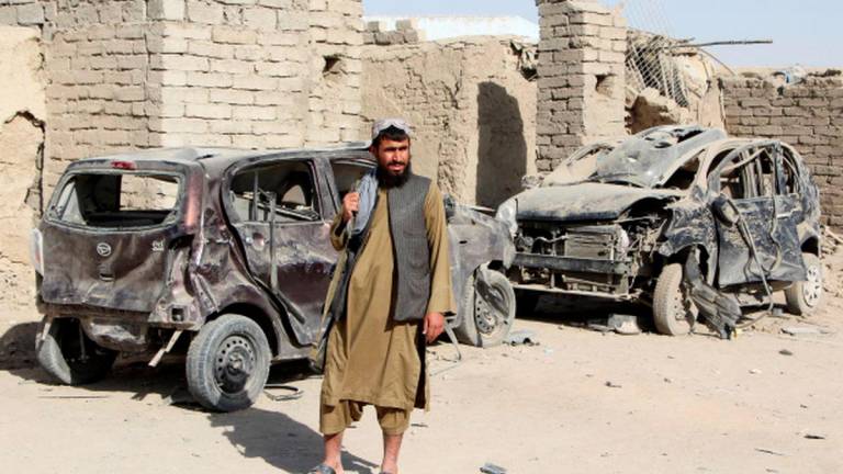 A Taliban fighter stands next to vehicles destroyed during an airstrike, following a temporary ceasefire, amid the conflict between Afghanistan and Pakistan, in Spin Boldak district of Kandahar Province, Afghanistan, October 16, 2025. - REUTERSPIX