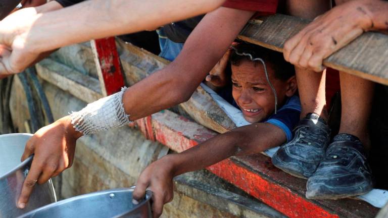 A Palestinian child waits to receive food from a charity kitchen, amid a hunger crisis, in Gaza City. Reuters/TPX Images of the Day