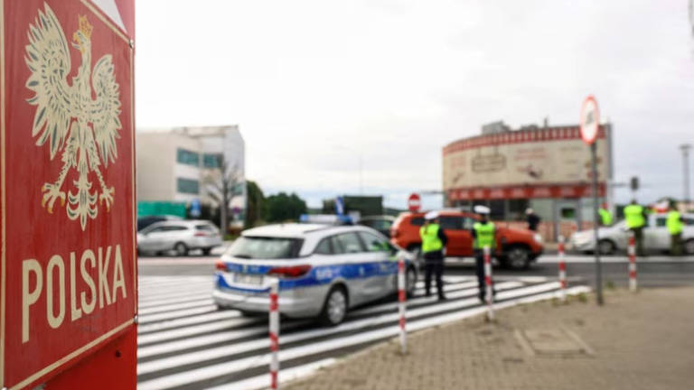 A border stone of Poland is seen as Polish border guards check a vehicle at Polish-German border, as Poland starts controls on borders with Germany, Lithuania over migration, near the German town of Frankfurt an der Oder, in Slubice, Poland, July 7, 2025. - REUTERS