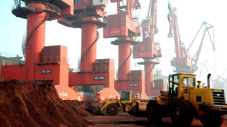 Pekerja mengangkut tanah yang mengandungi unsur nadir bumi untuk dieksport di sebuah pelabuhan di Lianyungang, wilayah Jiangsu, China. REUTERS