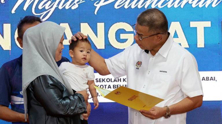 Menteri Dalam Negeri Datuk Seri Saifuddin Nasution Ismail (kanan) menyerahkan sijil kelahiran kepada penerima pada Majlis Peluncuran Kampung Angkat MADANI Kementerian Dalam Negeri di Kampung Pangkalan Abai hari ini- BERNAMA
