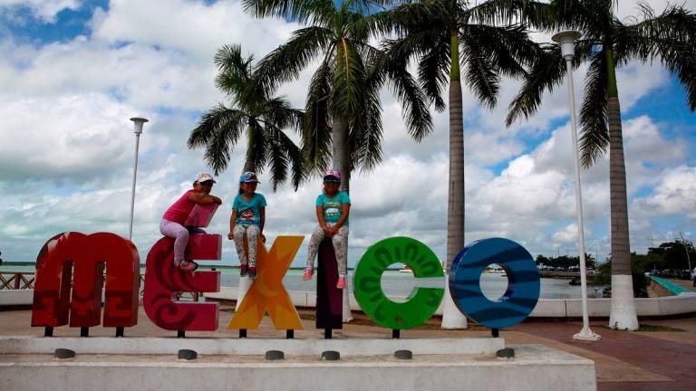 Children sit on top a sign in Chetumal in the state of Quintana Roo, Mexico August 3, 2016. REUTERSpix