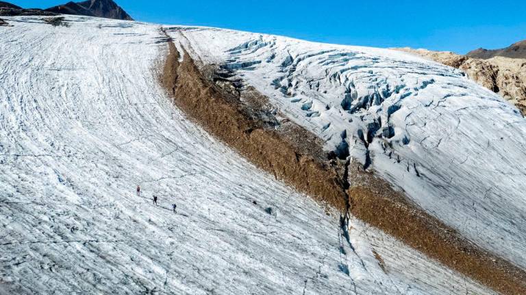 A drone view shows Matthias Huss, glaciologist at ETH Zurich and Head of the GLAMOS, walking on the Gries glacier with colleagues Lander van Tricht and Andreas Linsbauer on a warm summer day, amid climate change, in Obergoms, Switzerland September 11, 2025. REUTERS/Denis Balibouse
