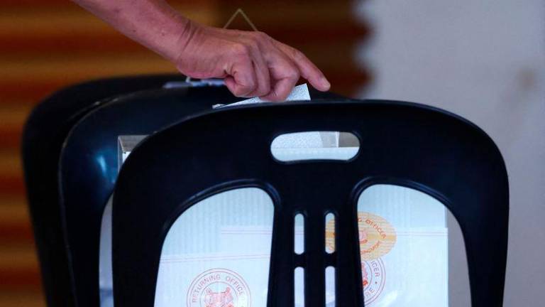 A person votes at a polling station during the general election, in Singapore May 3, 2025. - REUTERSPIX