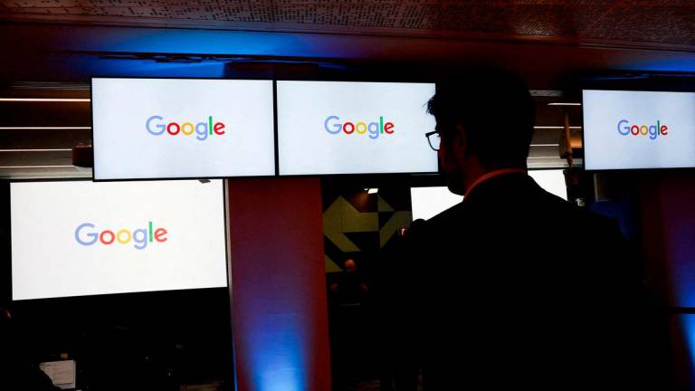 FILE PHOTO: A man stands in front of Google logos during a media reception at the Google France headquarters ahead of the Artificial Intelligence Action Summit in Paris, France, February 9, 2025. REUTERS/Gonzalo Fuentes/File Photo