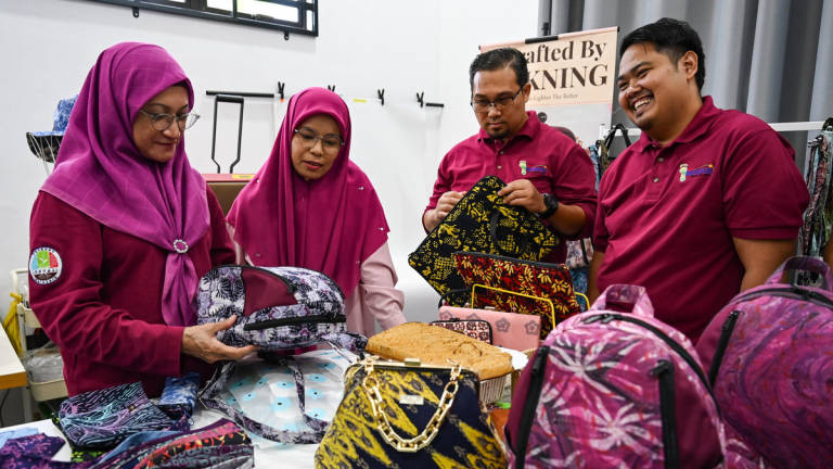 Chief Executive Officer of Yayasan Inovasi Malaysia (YIM), Dr Sharmila Mohamed Salleh (left), observes the making of Modular Batik crafts during the 2025 Social Innovation Trail (JIS) Programme for the East Zone at Kampung Banggol Donas yesterday. – BERNAMA