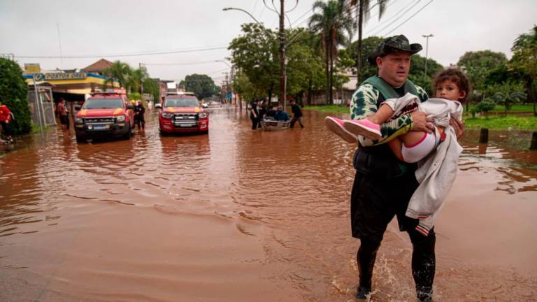 A child is evacuated from a flooded area in Porto Alegre, Rio Grande do Sul State, Brazil, on May 4, 2024. The death toll from floods and mudslides triggered by torrential storms in southern Brazil has climbed to 58 people, with the major city of Porto Alegre particularly hard-hit, the country's civil defense agency said Saturday.- AFPPIX