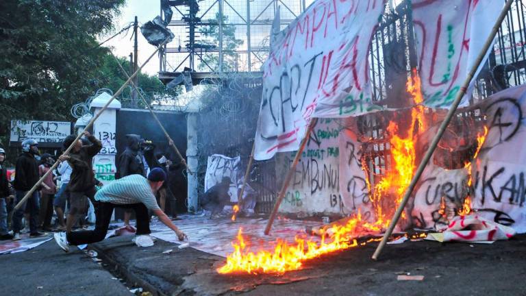 Protesters throw bamboo sticks while setting banners on fire at the gate of the regional parliament building during a protest against the government's spending priorities, such as enhanced perks for lawmakers, in Bandung, West Java province, Indonesia, September 1, 2025. - REUTERSPIX