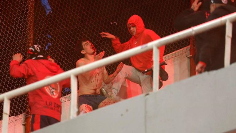 A man bleeds during the interruption of the Copa Sudamericana round of 16 second leg football match between Argentina’s Independiente and Chile’s Universidad de Chile at the Libertadores de America stadium in Avellaneda, Buenos Aires province, Argentina on August 20, 2025. - Alejandro PAGNI / AFP