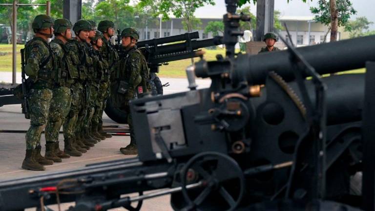 Taiwanese soldiers stand in formation beside US-made M101 howitzers during a visit by Taiwan's President Lai Ching-te at the air force base in Hualien on May 28, 2024. - Sam Yeh / AFP
