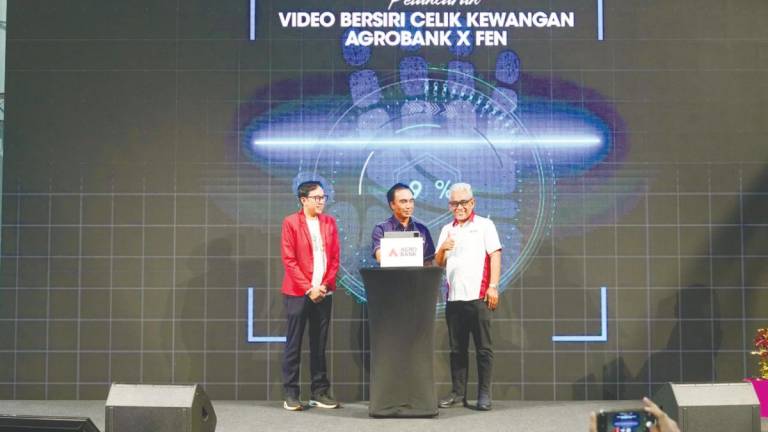 Bank Negara Malaysia deputy governor Adnan Zaylani Mohamad Zahid (cenre) launching the financial literacy video series, witnessed by Tengku Ahmad Badli Shah (right) and Sir Asai.