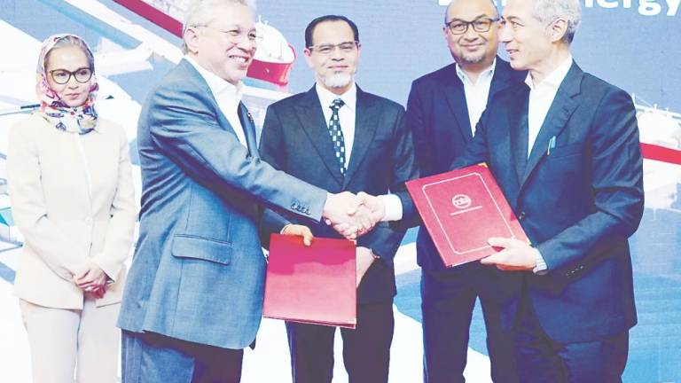 Che Wan Adlil (left) and MBI Terengganu financial adviser Mohd Badaruddin Ismail exchanging documents. Looking on are, from left, Hanim, Terengganu State Digital Economy New Income, Trade Industry and Green Technology Committee chairman Mohd Nurkhuzaini Ab Rahman and Energy Commission of Malaysia director of strategic planning and communication Rumaizi Abdul Halim.