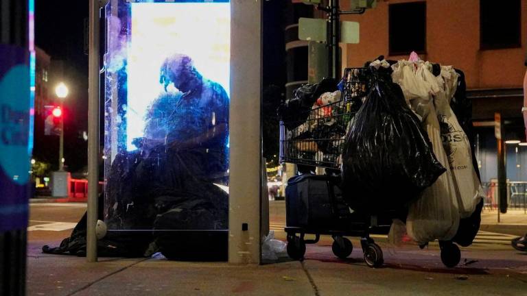 A homeless person sits at a bus stop in Dupont Circle, in Washington, D.C., U.S., August 11, 2025. - REUTERSPIX