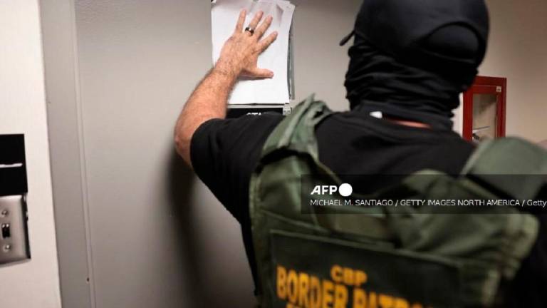A federal agent blocks a window where detainees are being questioned outside of immigration court at the Jacob K. Javitz Federal Building on July 30, 2025 in New York City. - Michael M. Santiago / GETTY IMAGES NORTH AMERICA / Getty Images via AFP