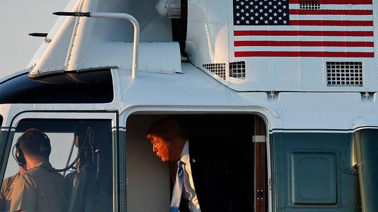 U.S. President Donald Trump speaks to the pilots of the Marine One presidential helicopter before walking to Air Force One on September 22, 2025 at Joint Base Andrews, Maryland. - CHIP SOMODEVILLA / GETTY IMAGES NORTH AMERICA / AFP