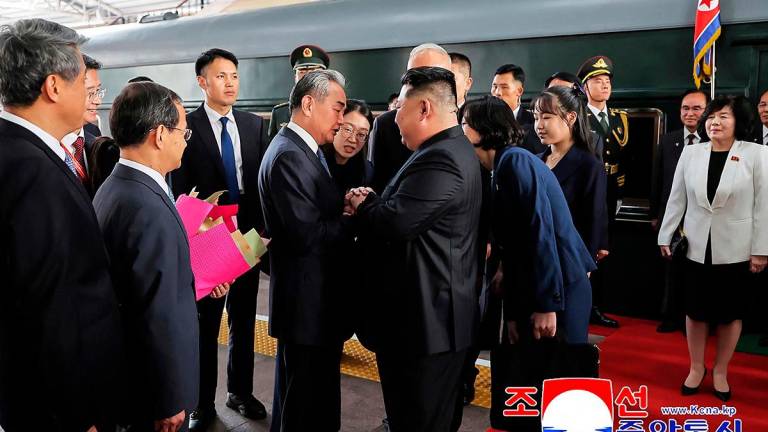 This photograph taken on September 2, 2025 and released by North Korea’s official Korean Central News Agency (KCNA) via KNS shows North Korea’s leader Kim Jong Un (centre R) and his daughter Kim Ju Ae (4th R) being greeted by China’s Foreign Minister Wang Yi (centre L) upon their arrival at the Beijing Railway Station in Beijing. - KCNA VIA KNS / AFP